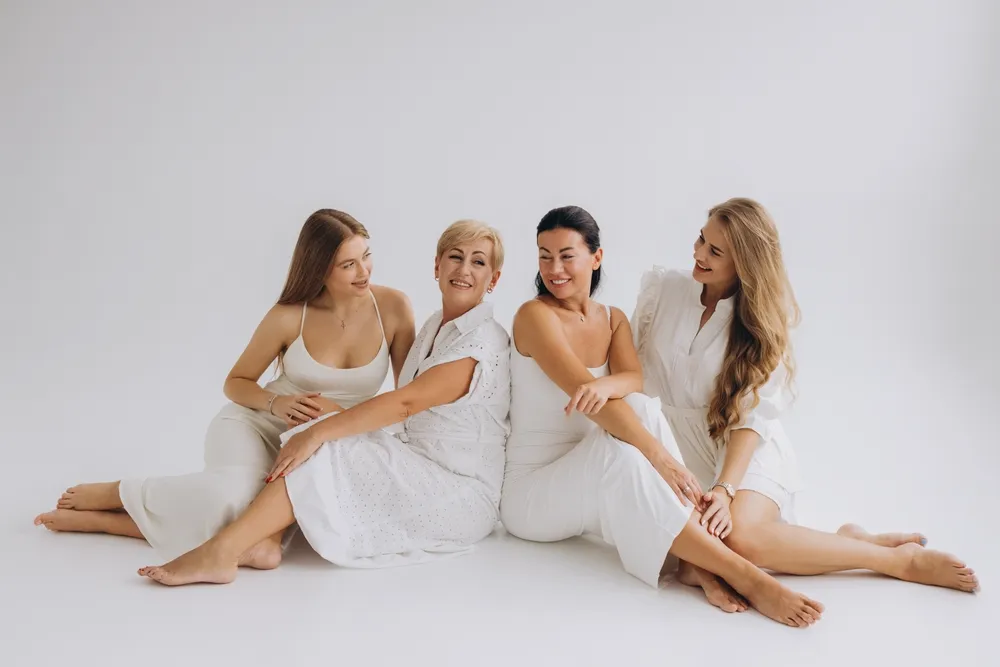Four women of different ages sitting together, smiling