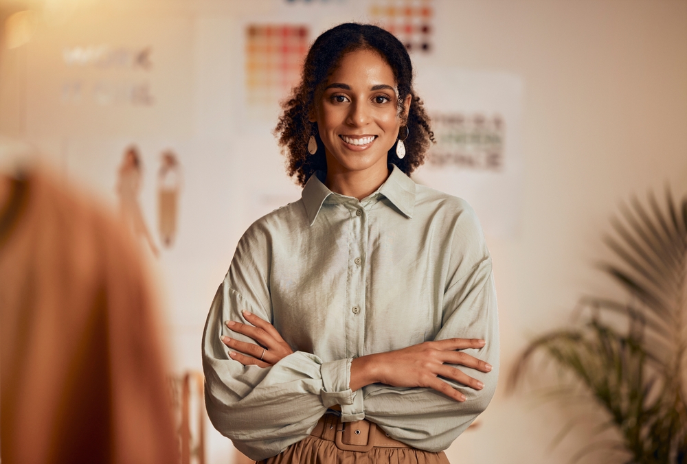 A woman standing with her arms folded, smiling