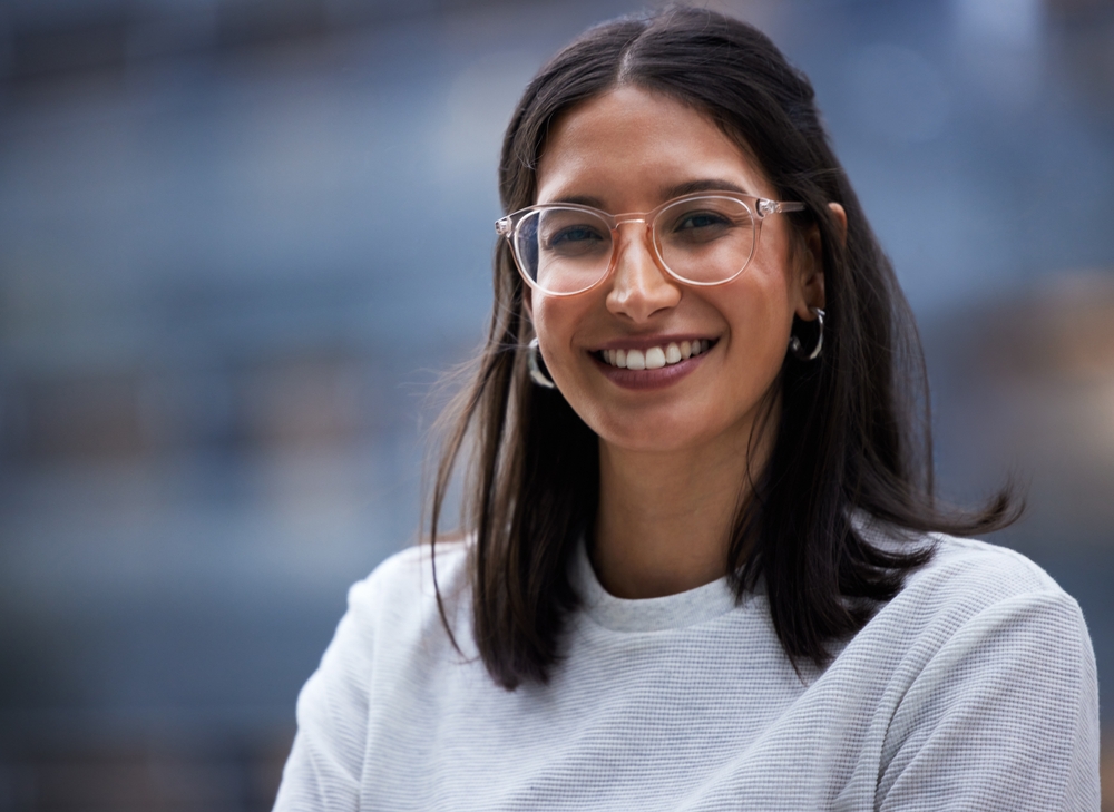 A young woman in glasses smiling