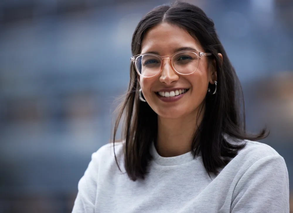 A young woman in glasses smiling