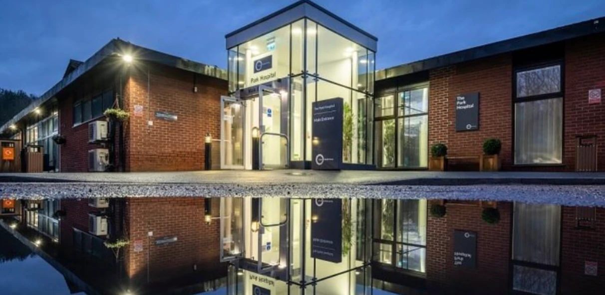The Park Hospital main entrance at dusk, reflected in water