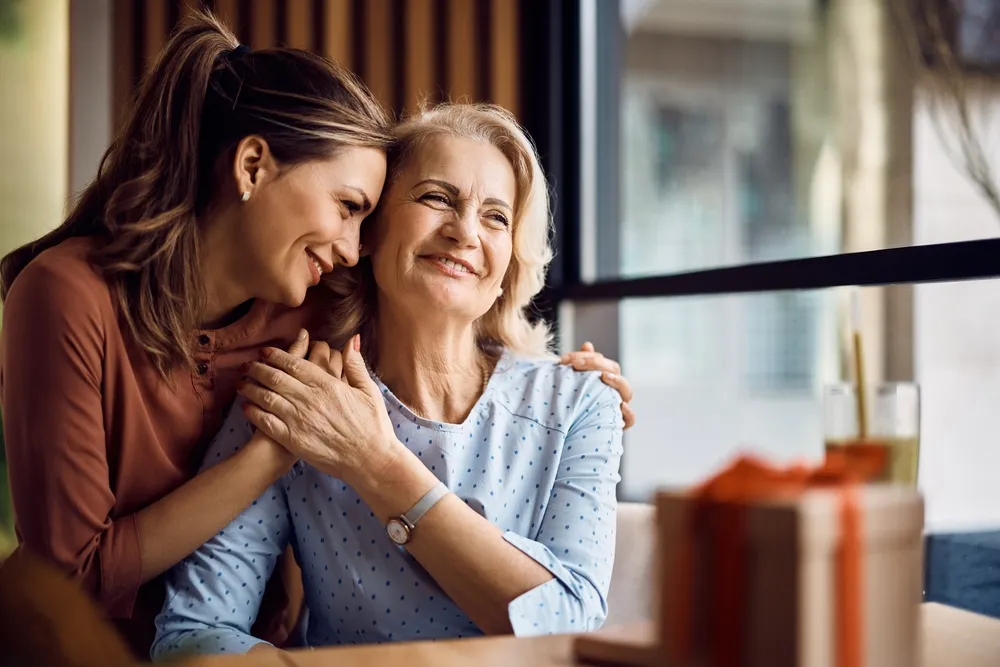 A daughter hugging her smiling mother